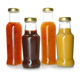 Bottles with tasty sauces on white background