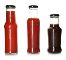 Bottles with tasty sauces on white background