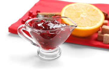 Gravy boat with tasty cranberry sauce and blurred products on background