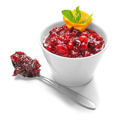 Bowl with tasty cranberry sauce, orange and mint on white background