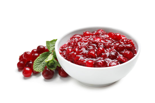 Bowl with tasty cranberry sauce on white background