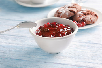 Bowl with tasty cranberry sauce on table