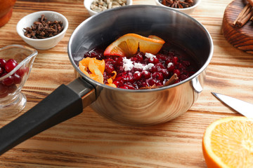 Saucepan with delicious cranberry sauce on table