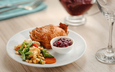 Tasty dish served with cranberry sauce on plate