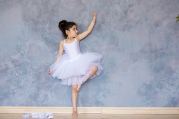 Fototapeta na wymiar Little girl ballerina in a white tutu
