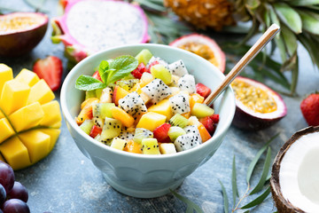 Fruit salad with tropical fruits mango, coconut, pitaya in a bowl. Thai summer holiday vegan food. Concept of healthy lifestyle, healthy eating, vegetarian diet