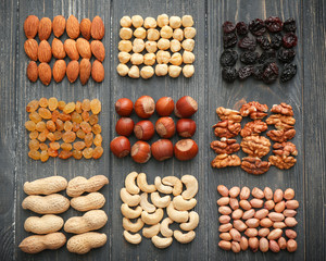 Different kinds of nuts and dried fruits on wooden background, top view