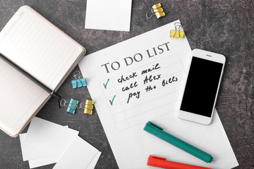 To-do list with phone and stationery on grey background