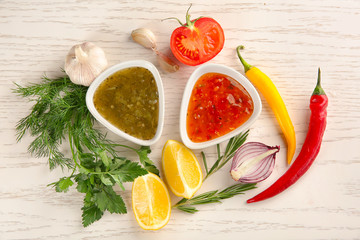 Composition with different sauces on white wooden table, top view