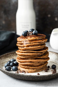 Oat pancakes with blueberry, chocolate and honey. Healthy pancakes. Healthy breakfast or snack concept. Closeup view stack of pancakes