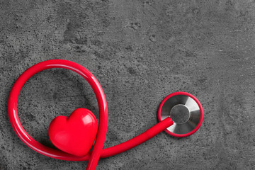 Stethoscope with small heart on dark grey background