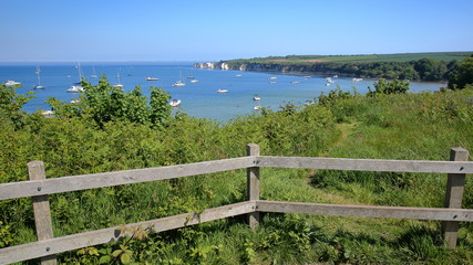 Studland bay with mooring boats and Old Harry Rocks in the background near Swanage, Isle of Purbeck, Dorset, UK