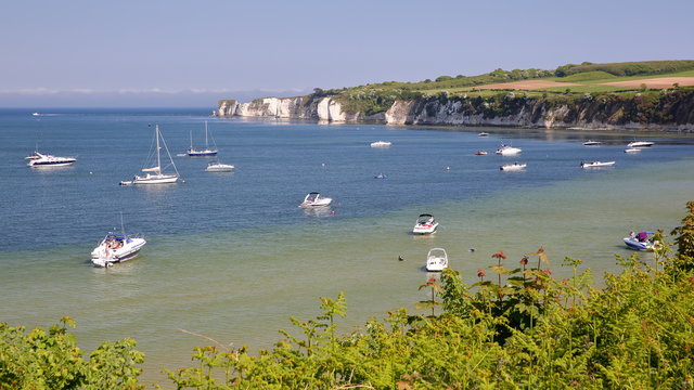 Studland bay with mooring boats and Old Harry Rocks in the background near Swanage, Isle of Purbeck, Dorset, UK