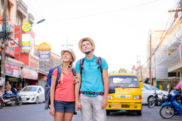 Travel and tourism. Couple of backpackers walking together on asian street.