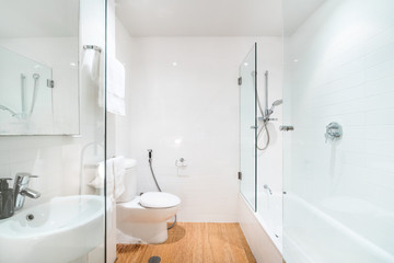 Modern bathroom interior with bathtub and light coloured decor.