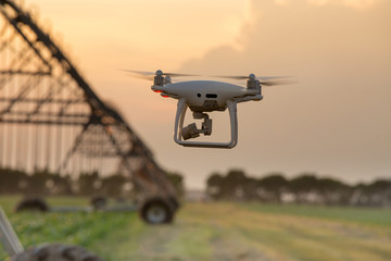 Drone flying in front of irrigation system in field - obrazy, fototapety, plakaty