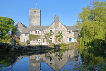 Fototapeta na wymiar Reflections of Mill Pond cottages and St Mary's Church in Church Hill, Swanage, Isle of Purbeck, Dorset, UK
