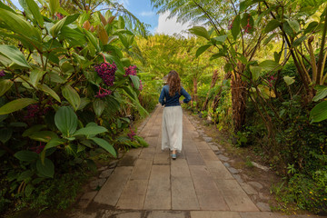 Fototapeta na wymiar Girl walking trough a botanical garden in Hell-Bourg, Reunion Island