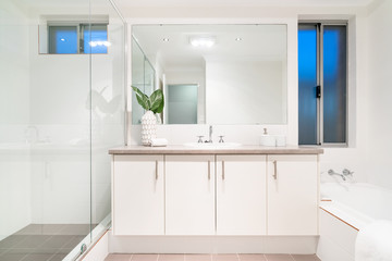 Modern bathroom interior with bathtub and light coloured decor.