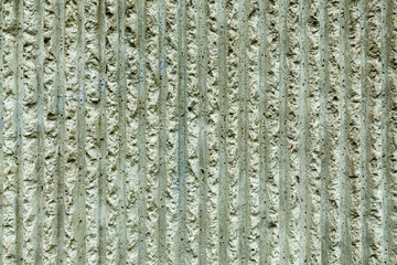 Surface of the wall with a decorative white plaster. Textured concrete wall with vertical lines and stripes as a texture or background. Repair, design concept.