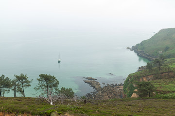 foggy day on the coast with green grass on the rocks Crozon, France 29 May 2018