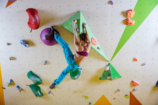 Young woman climbing in bouldering gym
