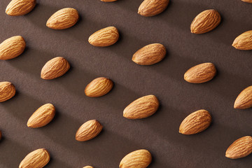 Pattern of almond nuts on a brown paper background