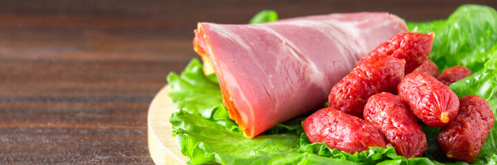 Assorted meat products including ham and sausages. banner