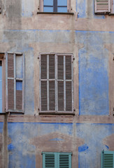 Fototapeta na wymiar Old shutters on a blue wall in Peille, France
