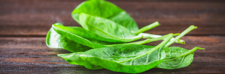 Green fresh spinach leaves on a wooden table banner