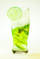 summer cold drink mojito lime and mint with ice and soda with drops on a glass on a white background