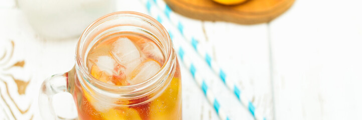 Homemade iced lemonade with ripe peaches. Fresh peach ice tea in a mason jar. Top view.