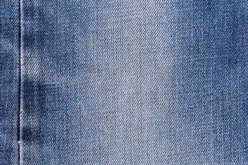 Naklejka premium Denim jeans fabric texture background with seam for clothing, fashion design and industrial construction concept.