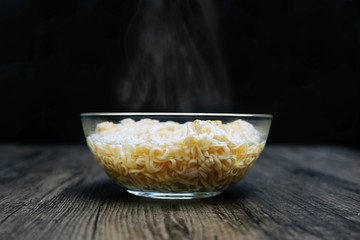 Close up of instant noodle in the glass bowl on black background.