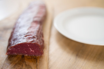 raw beef for making filet mignon steaks on wood board