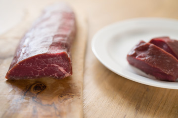 raw beef for making filet mignon steaks on wood board
