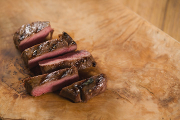 sliced medium filet mignon on wood board