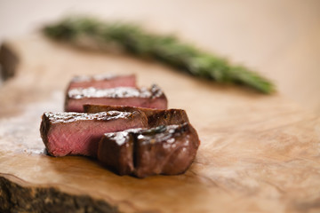 sliced medium filet mignon on wood board