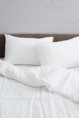 Cozy bed with crumpled white linen