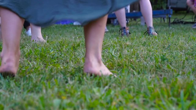 Ground level view of friends jumping and dancing barefoot in the garden at a summer party