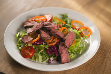 salad with sliced filet mignon steak