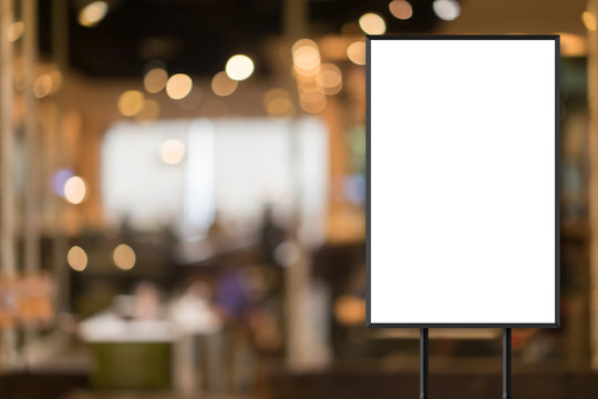 mock up blank white poster standing on blur restaurant background for show or promote promotion 