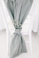 Wedding chair decor with white flowers and grey cloth