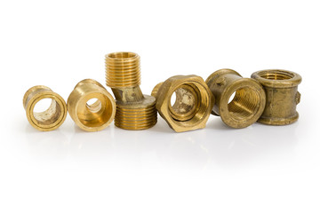 Brass eccentric connectors and other plumbing components on white background