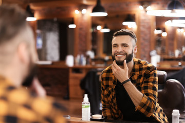Handsome man with trendy hairstyle in barbershop