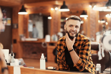 Handsome man with trendy hairstyle in barbershop