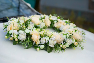 The composition from fresh flowers on the holiday car.