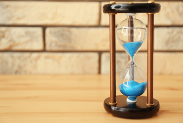 Hourglass on wooden table. Time management concept