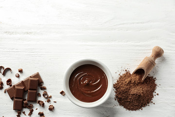 Flat lay composition with delicious chocolate on wooden background