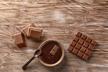 Flat lay composition with delicious chocolate on wooden background